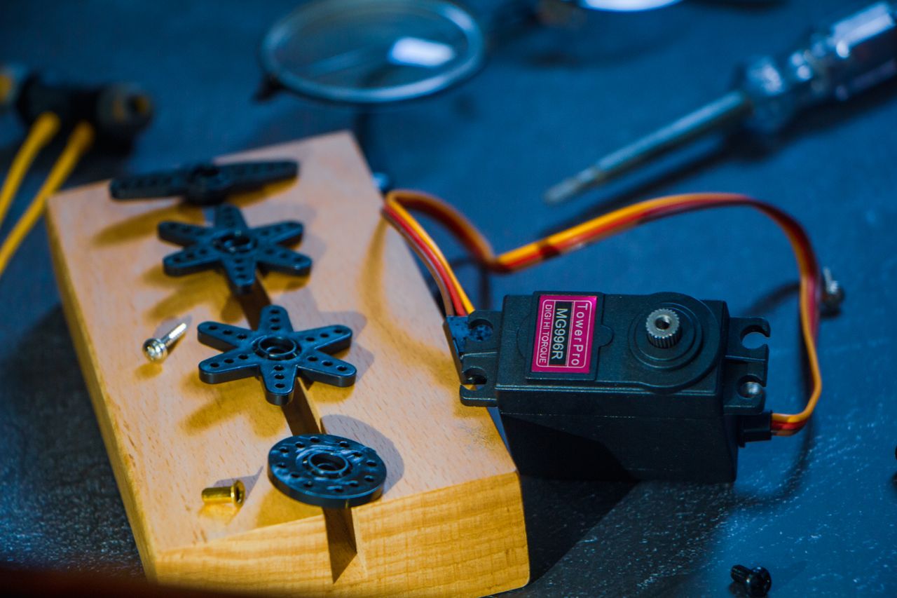 A servo motor and gear set on a wooden block, perfect for robotics enthusiasts and engineers.